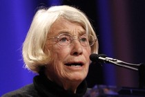 The poet Mary Oliver speaks at a podium.