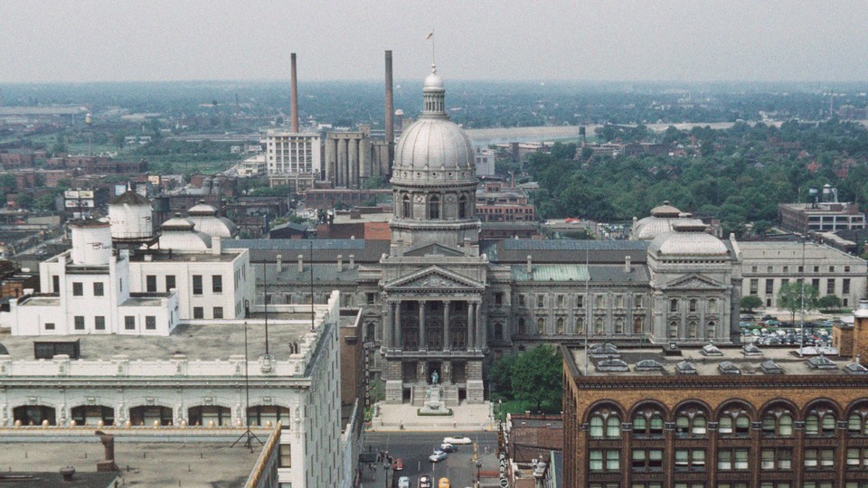 A color photo of Indianapolis, Indiana, seen from above, with the state capitol building seen at center.