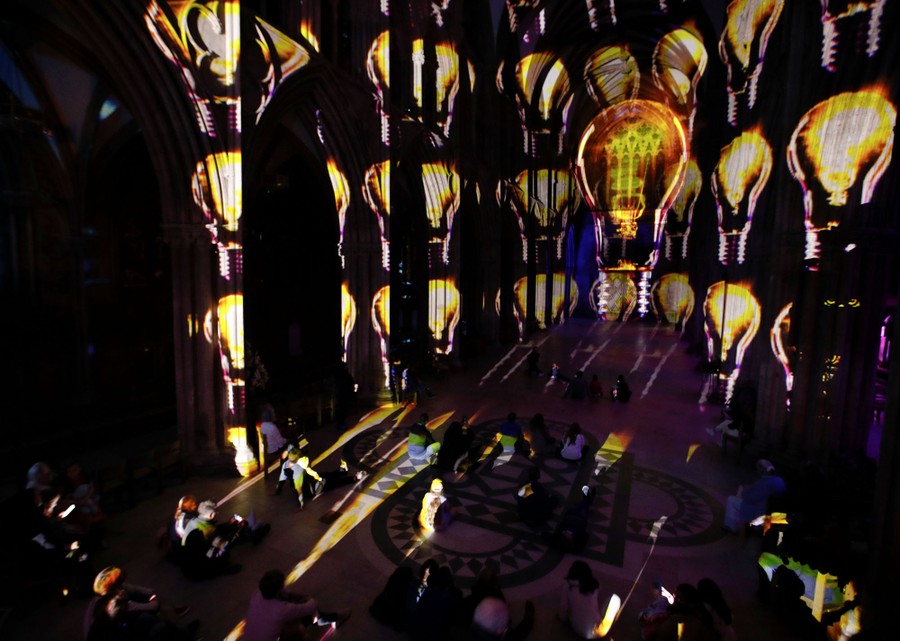 People watch a light show inside a cathedral.