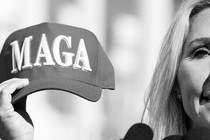 A photo of Marjorie Taylor Greene holding a MAGA hat