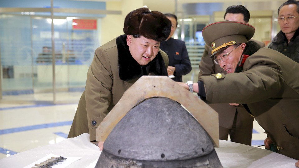 North Korean leader Kim Jong Un looks at a rocket warhead tip after a simulated test of atmospheric re-entry of a ballistic missile