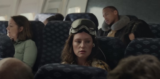 A woman wearing Apple Vision Pro on a plane