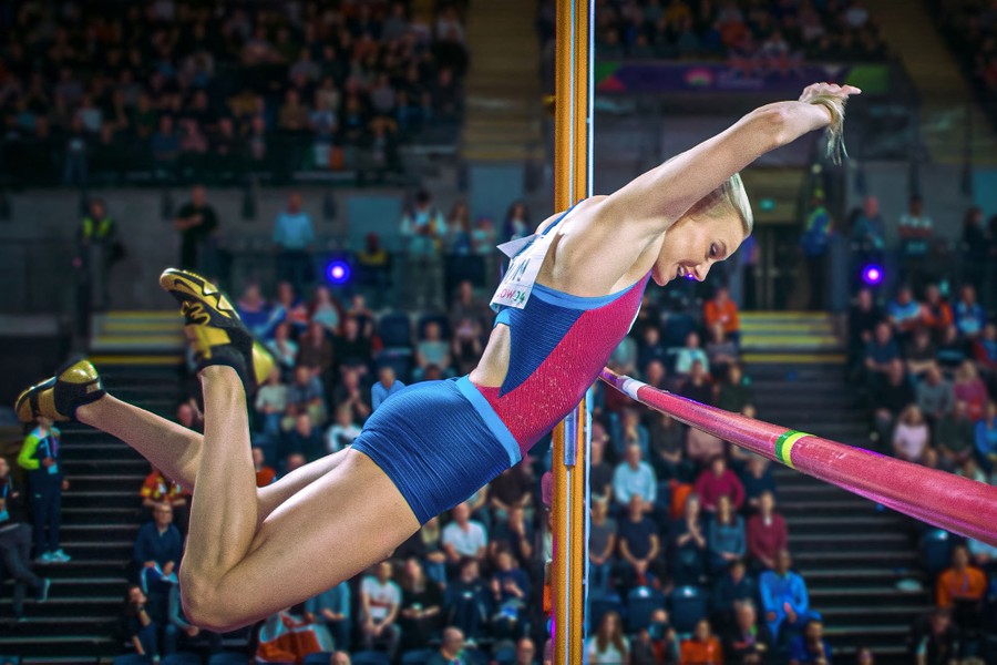 A pole vaulter clears the bar during a jump.