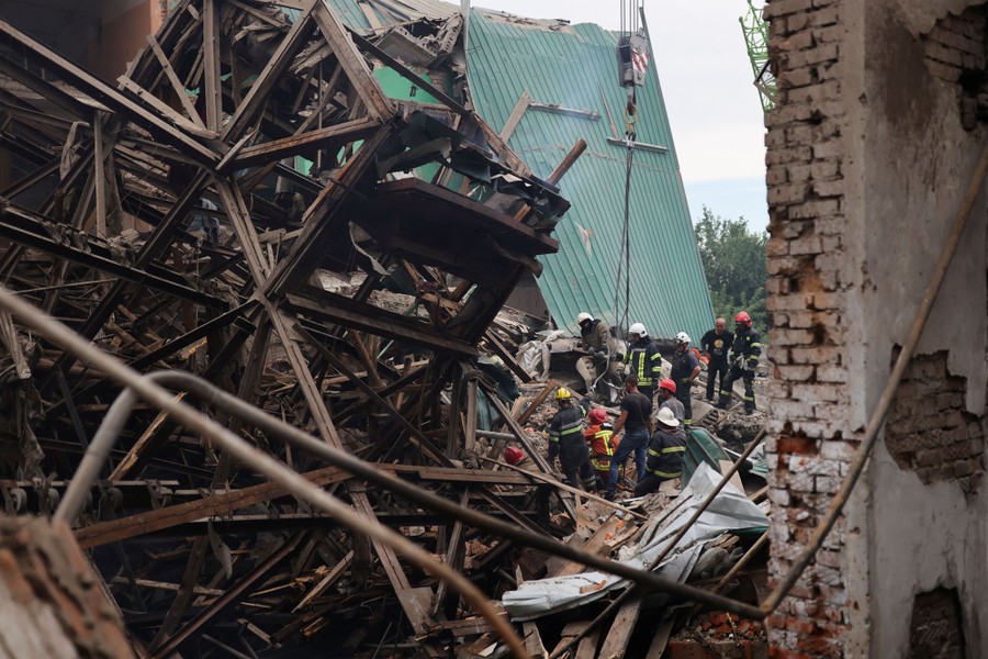 Firefighters remove debris to search for bodies in a heavily damaged building.