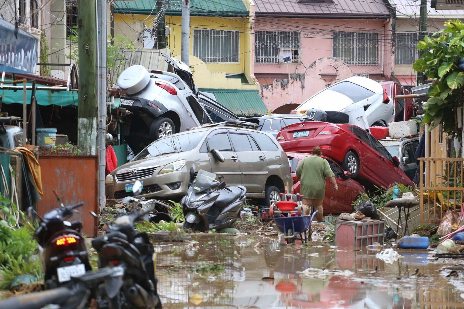 Vehicles lie piled up in a street after flooding caused by a typhoon.