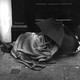 An unsheltered person sleeping under an umbrella in London