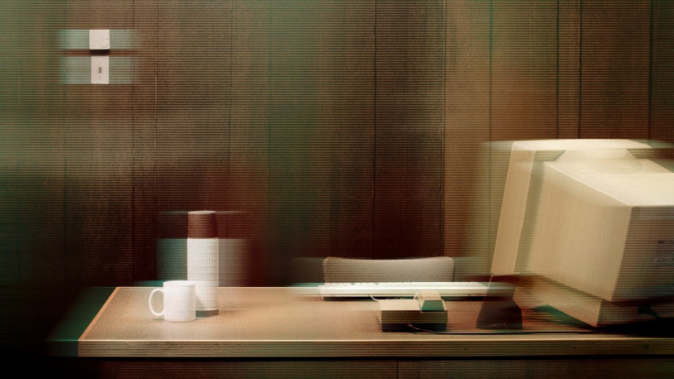 An empty desk with a boxy desktop monitor, keyboard, thermos, and coffee mug, with a stylized blur over it