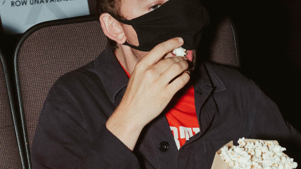 A masked moviegoer at a theater in Ne​w York