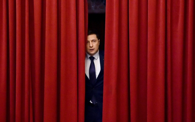Volodymyr Zelensky as the fictional president of Ukraine, peeking out from behind red curtains, in "Servant of the People"