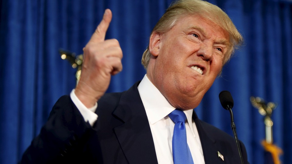 Donald Trump standing at a podium, making a distorted, mocking face and pointing his index finger upward.