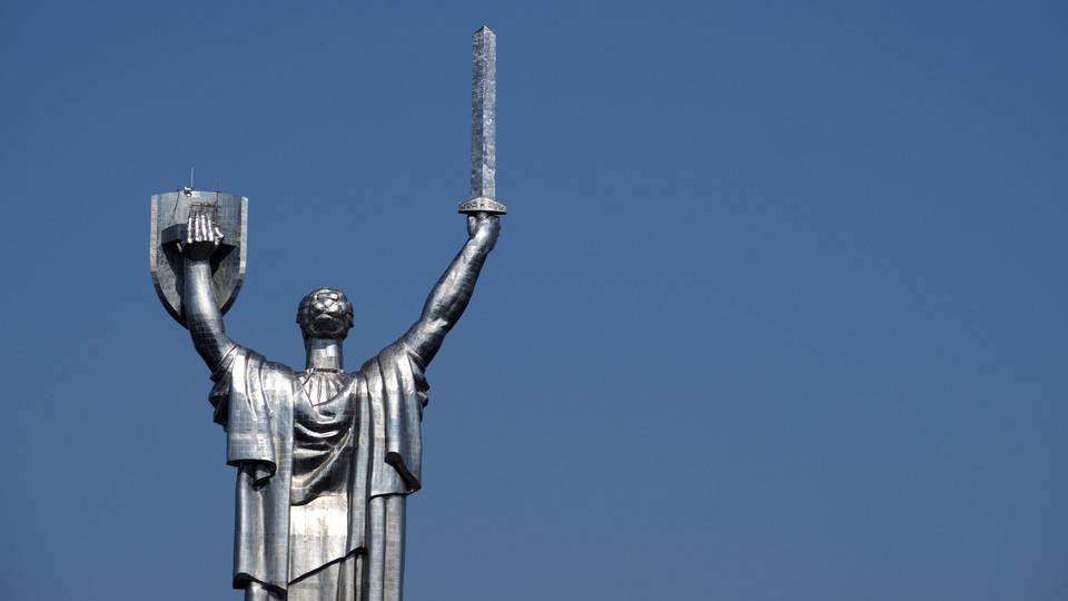 The Mother Motherland Monument statue in Kiev, showing a woman holding up a shield and sword