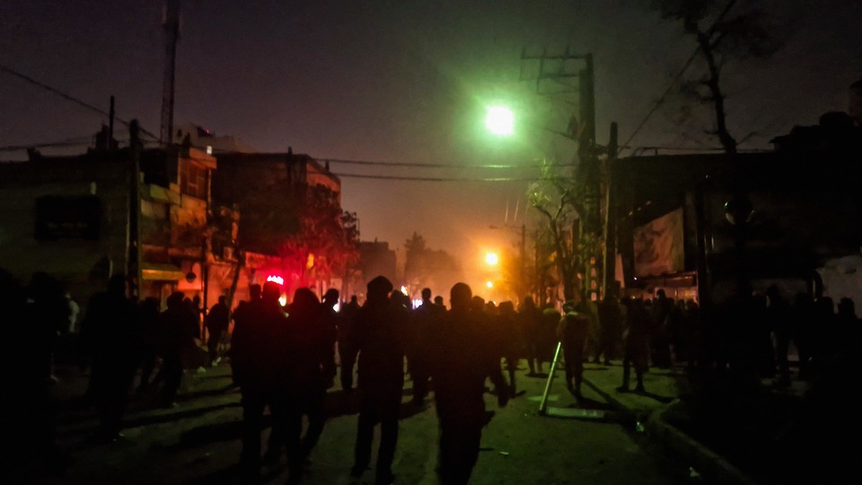 Protesters gather around a fire on a street in Mashhad the night f January 8