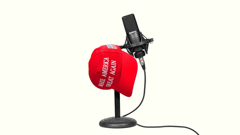 A red “Make America Great Again” cap resting on a podcast microphone