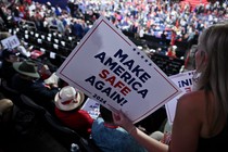 An attendee holds a "Make America Safe Again" sign on the second day of the 2024 Republican National Convention.