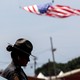 A state trooper stands next to a vehicle blocking a road leading to the event grounds in Butler, Pennsylvania.