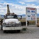 A tow truck parked beside a sign for the Little A'Le'Inn in Rachel, Nevada