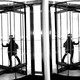 A woman walks through an office's revolving door next to a mirrored wall.