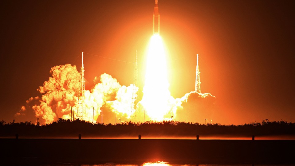 NASA's new moon rocket, the Space Launch System, lifts off from the launchpad, its engines blazing bright