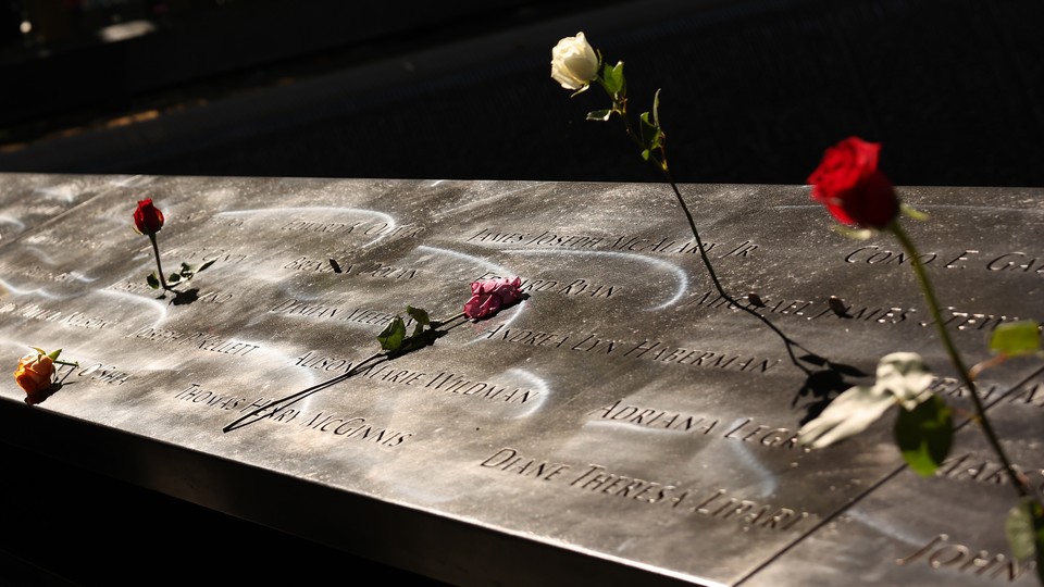 A part of the 9/11 memorial, with flowers over it