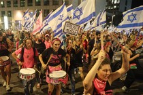 Demonstrators wave the flag of Israel during a march against the government's judicial reform plan in Tel Aviv
