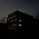 A building with a few lights on inside at dusk