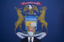 Joe Biden in front of the Michigan flag