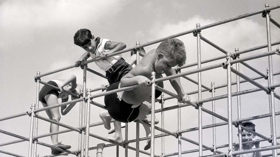 A black-and-white image of children playing on a jungle gym.