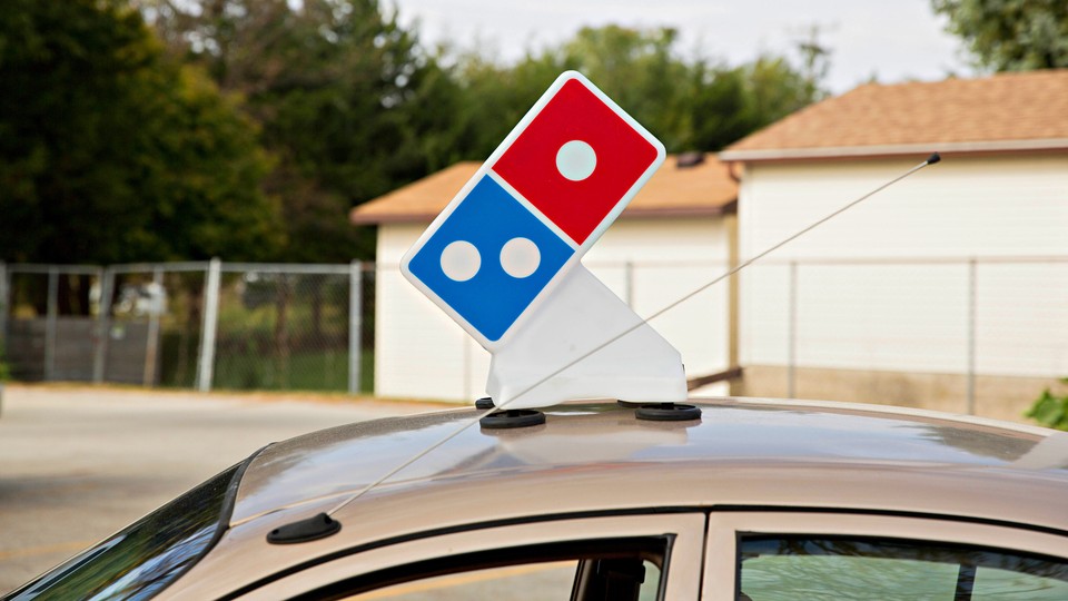 A delivery vehicle with a Domino's logo on top