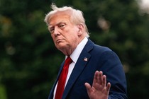 Donald Trump holds up his hand as he walks away