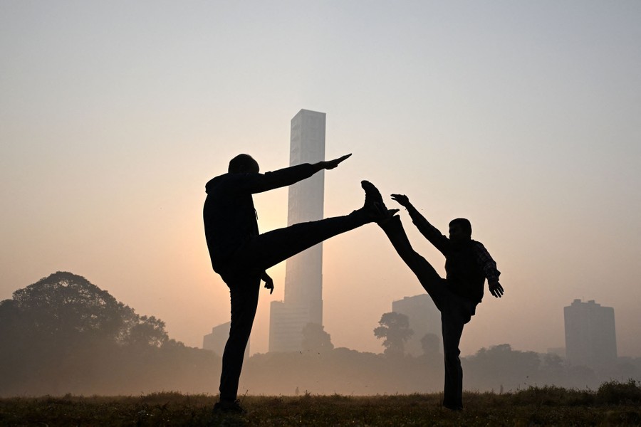 Two people exercise in a park on a foggy day.