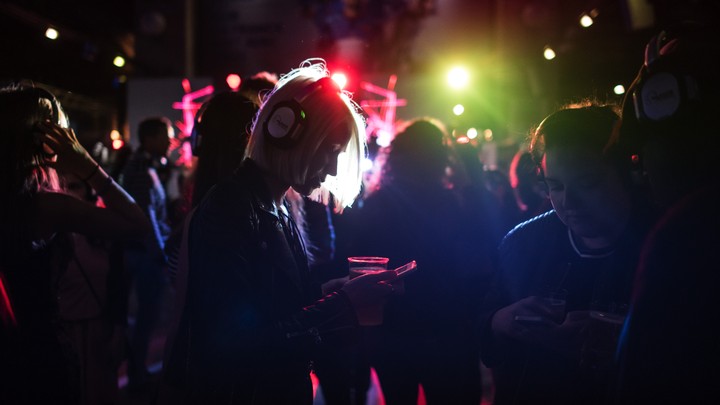A woman looks at her phone as she takes part in a silent disco.