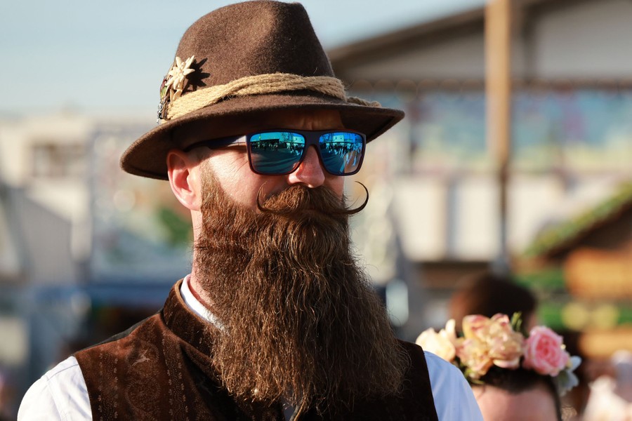 A man with a long beard wears a traditional Bavarian hat and vest.