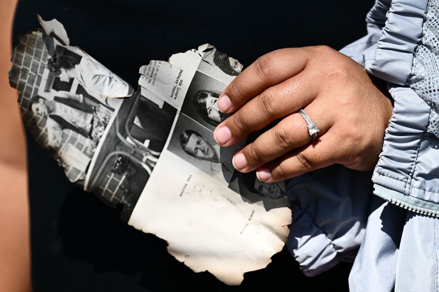 A person holds a burned page from a yearbook.