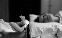 A mother looks at her newborn baby's feet