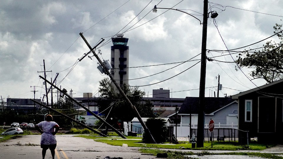 A woman looks over damage to a neighborhood caused by Hurricane Ida on August 30, 2021, in Kenner, Louisiana.