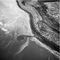 aerial black-and-white photo of spiral earthwork sticking out from shore into lake