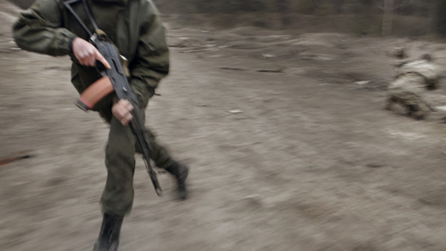 blurry image of a man running with a gun in combat gear