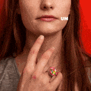 A person raises a finger to their chin as the word "Um" appears across the photo.