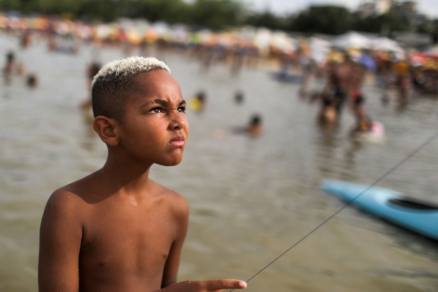 A boy looks up with a kite string in hand.