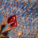 Supporters wave their hands in front of a Turkish flag