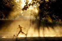 A photo of a child playing soccer