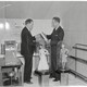 Two men in suits look at a steel tube inside Oglethorpe University's Crypt of Civilization.