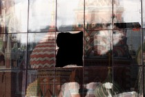 A broken window pane in building showing a reflection of the Kremlin.