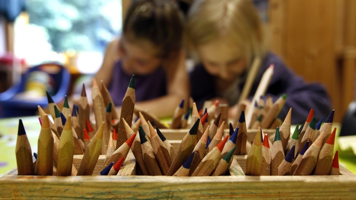 Two children draw with colored pencils