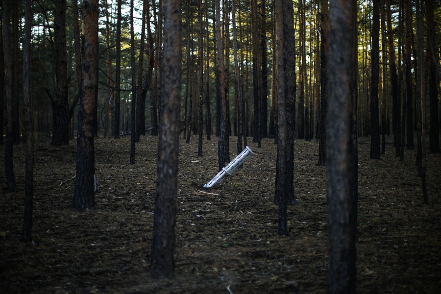 Part of a Russian rocket sticks out of the ground in a forest.