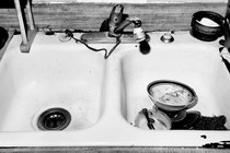 a black and white photo of a sink with bowls in it