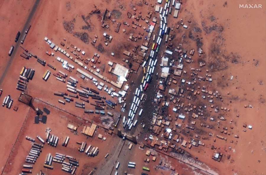 A satellite view of a border crossing with dozens of passenger buses sitting in a traffic jam.