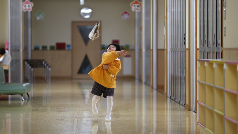 A boy plays in the hallway of a school in Japan