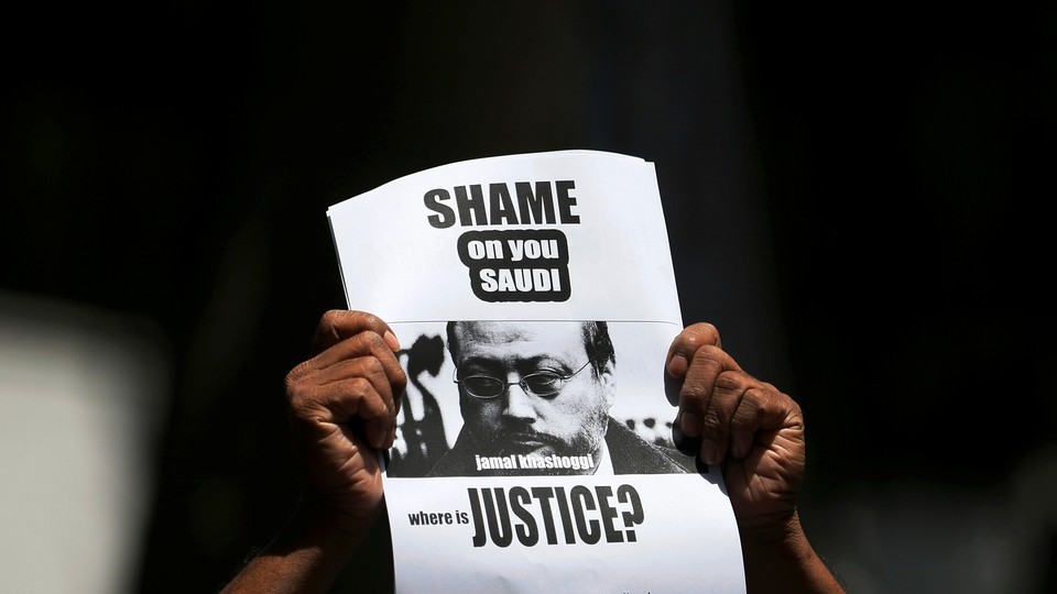 A protestor holds a sign that reads, "Shame on you Saudi. Where is justice?"