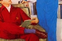 A reading boy looks up at a man